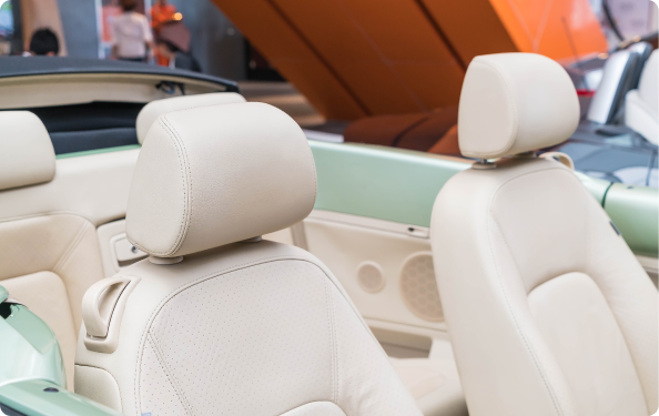 Close-up of beige car seats with headrests inside a vehicle.